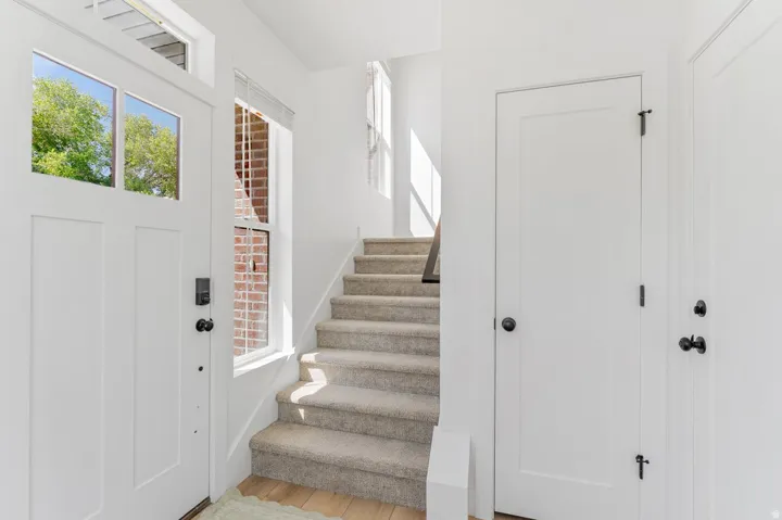 Entryway featuring a white paneled door with glass inserts, a smart lock, and matte black hardware