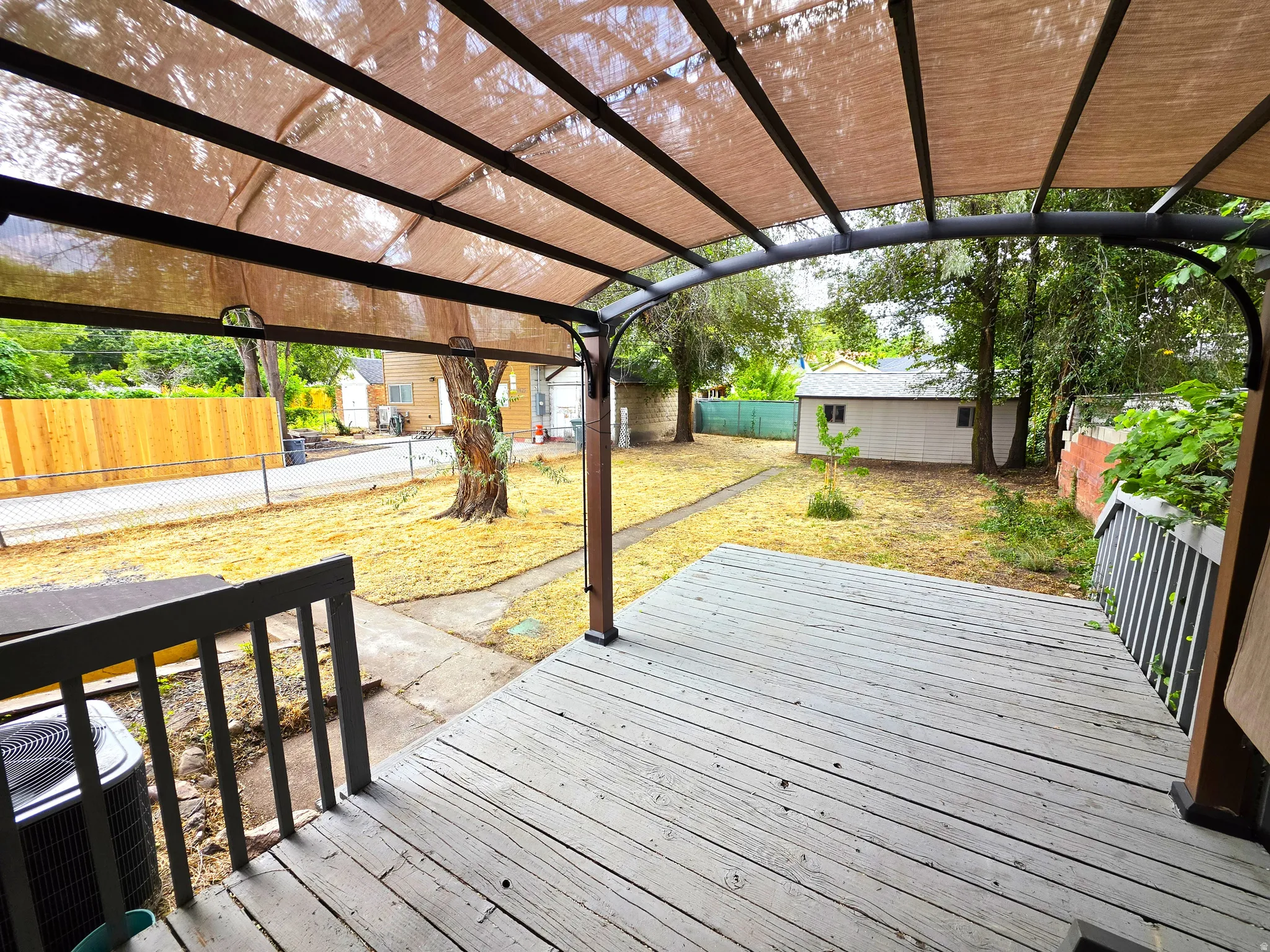 Outdoor deck with a metal pergola featuring a fabric canopy