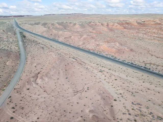 Expansive desert landscape featuring two paved roads traversing the terrain