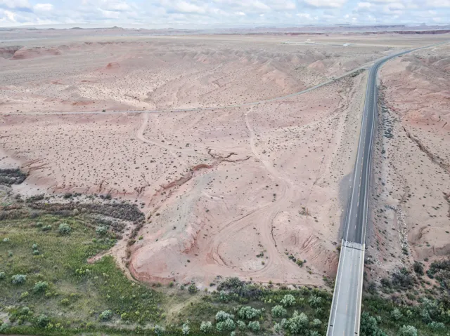 Expansive desert landscape featuring a paved highway and bridge structure