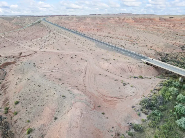 Expansive desert landscape featuring a paved highway and bridge structure