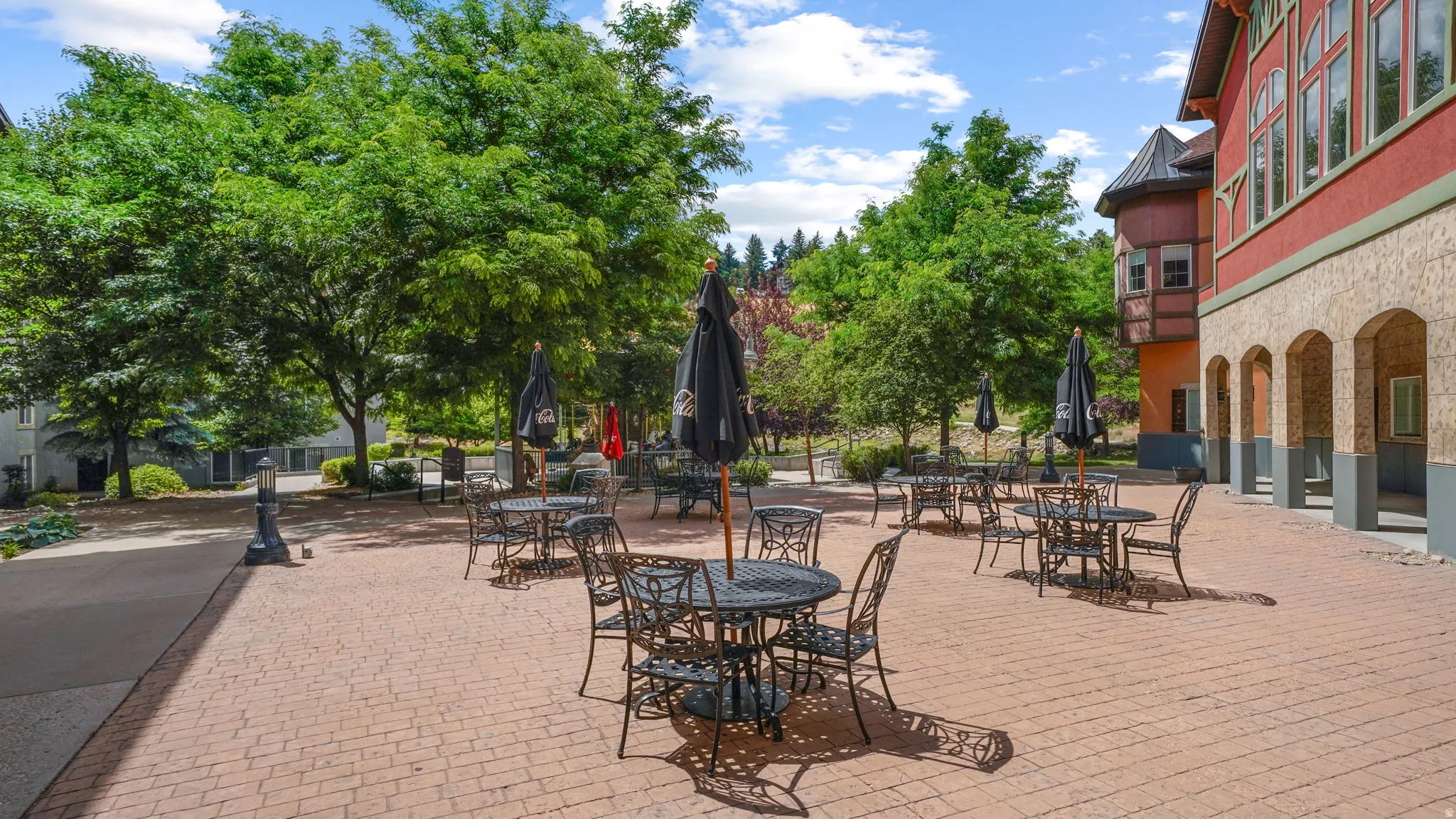 Expansive brick paver patio featuring multiple seating areas with tables and chairs