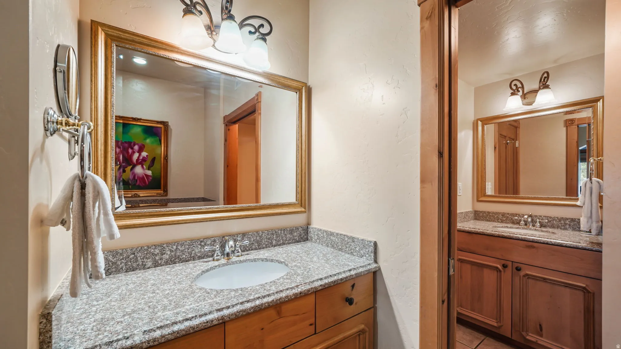 Vanity with a granite countertop, undermount sink, and wood cabinetry