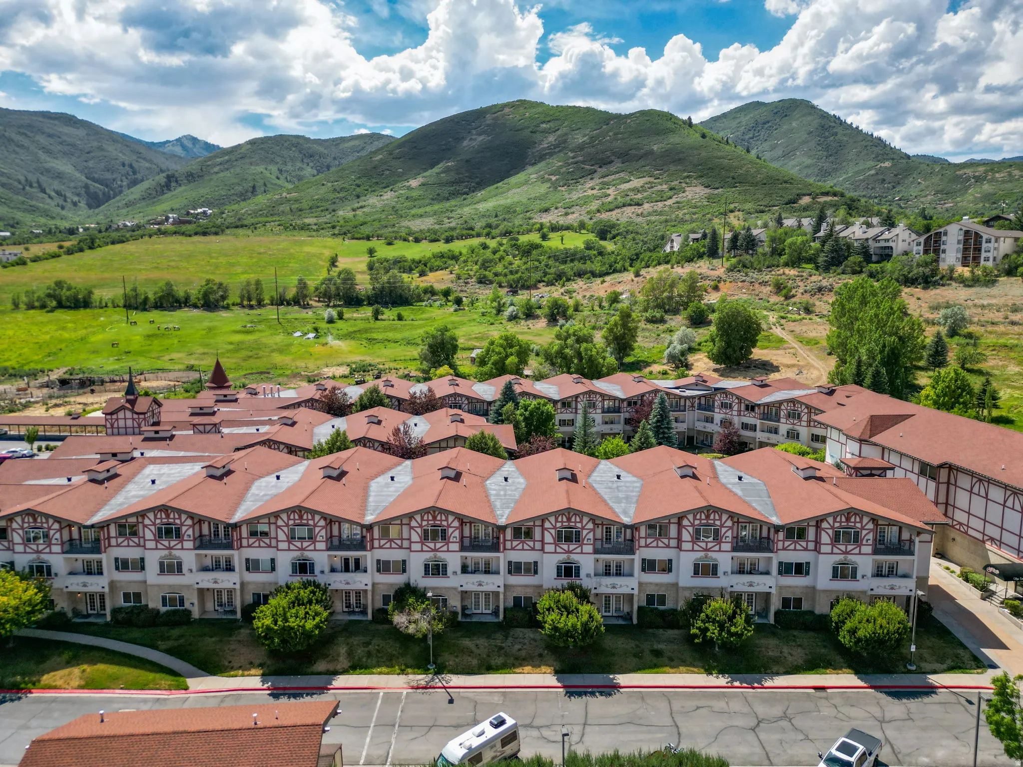 Alpine-inspired architecture featuring red tile roofs, white facades with dark timber accents, and multiple balconies