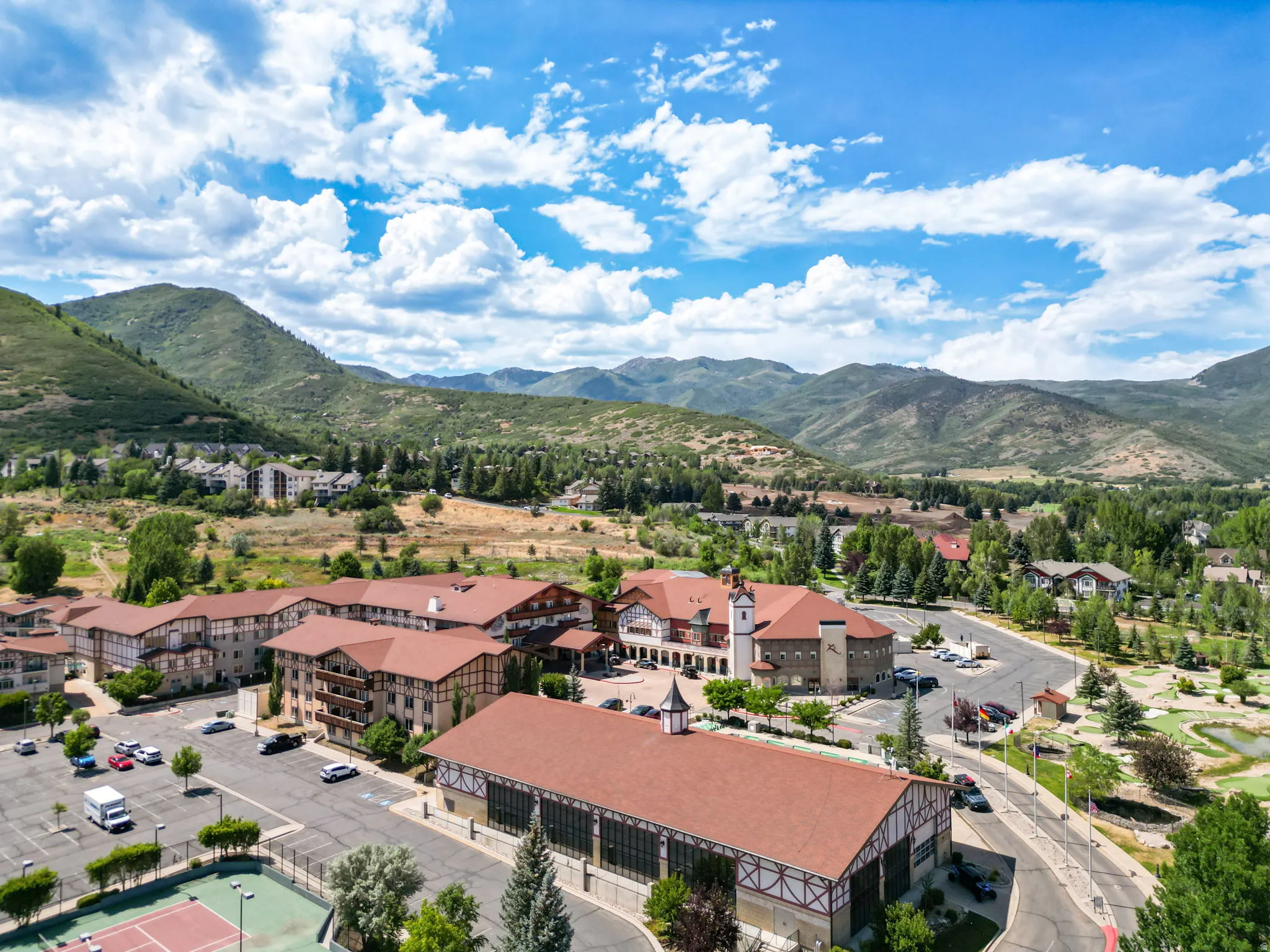 Expansive resort-style property showcasing multiple buildings with chalet-style architecture, red tile roofs, and exterior wood beam detailing