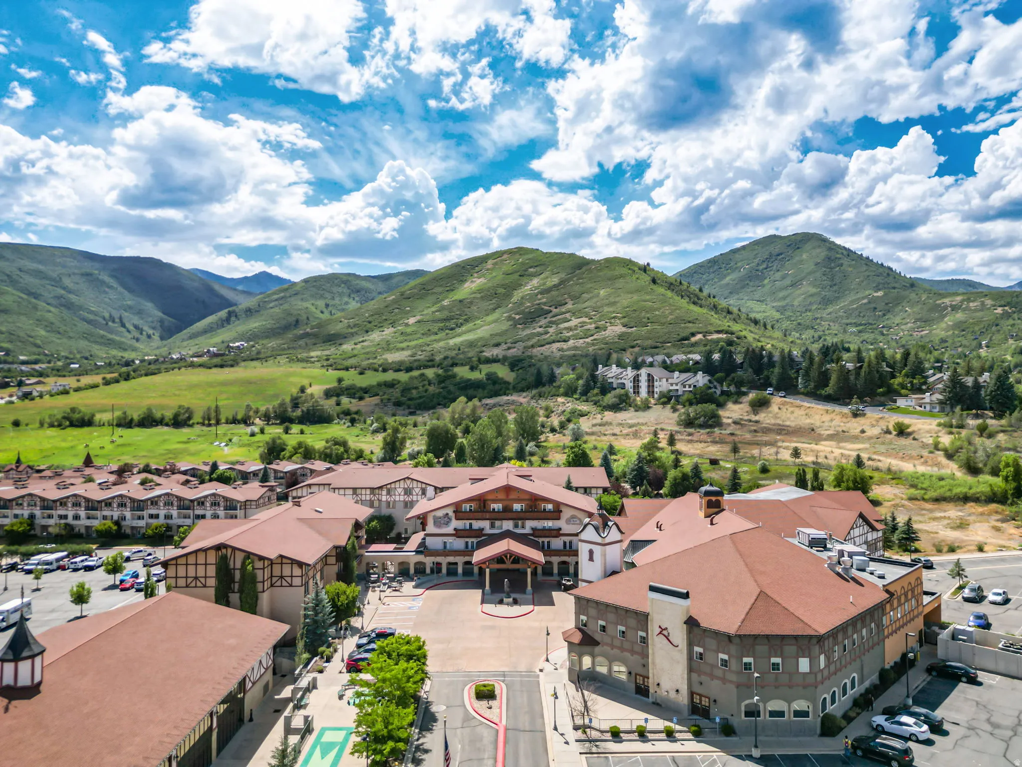 Expansive property featuring a collection of buildings with brown roofs and light-colored facades