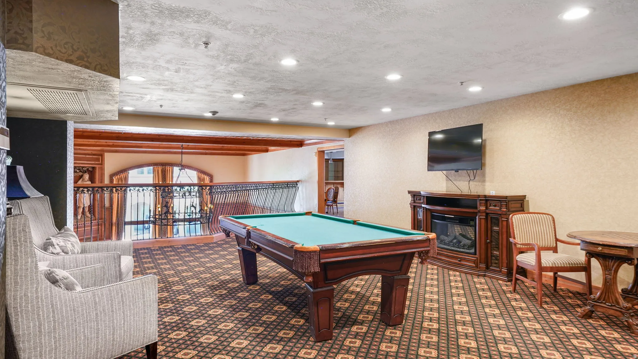 Recreation area featuring a billiards table, patterned carpet, recessed lighting, and a decorative console with an electric fireplace insert