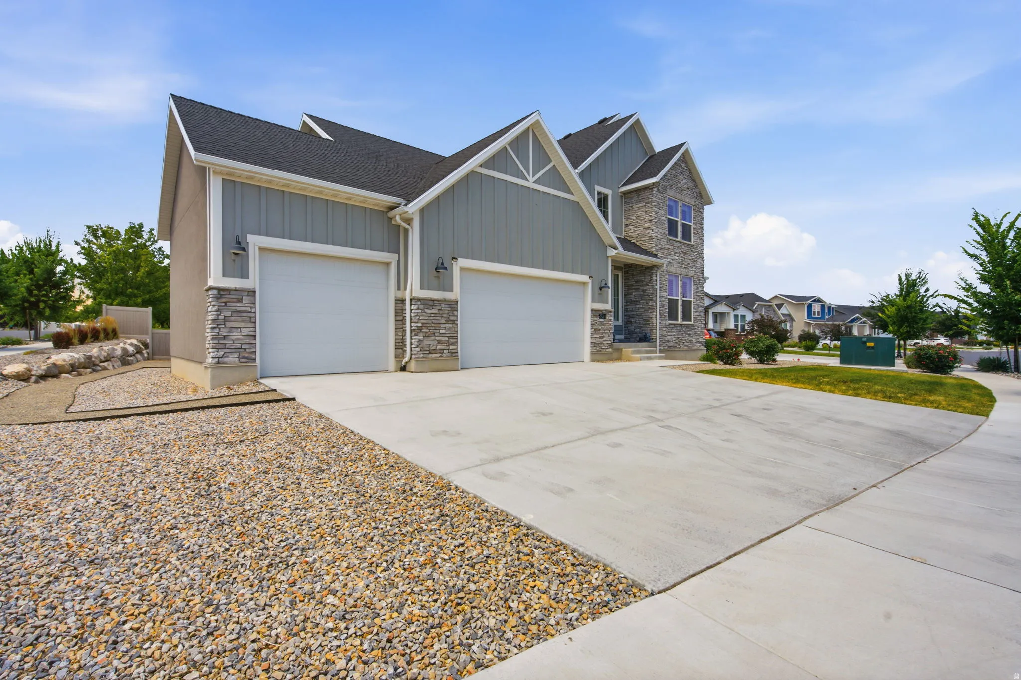 Modern exterior with a stone and siding facade, featuring a two-car garage with individual doors