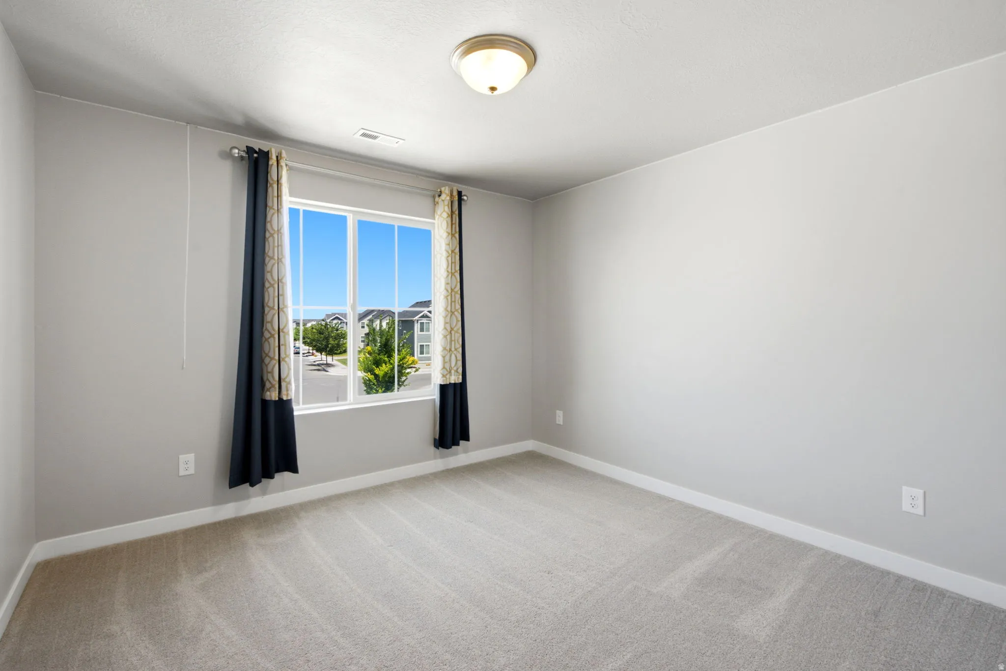 Bright interior space featuring a window with a neighborhood backdrop