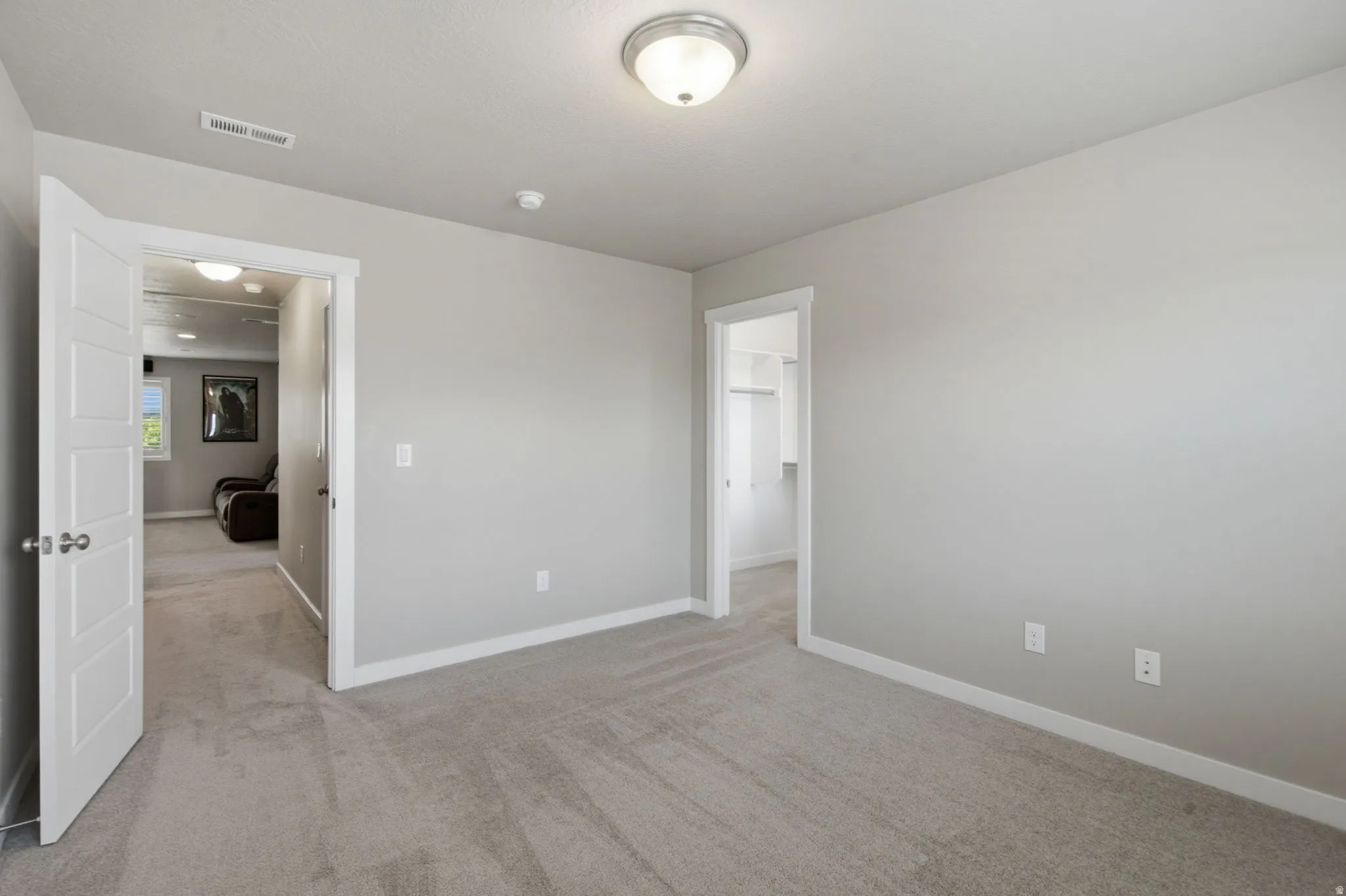Room featuring light gray wall paint, light gray carpeting, and white trim