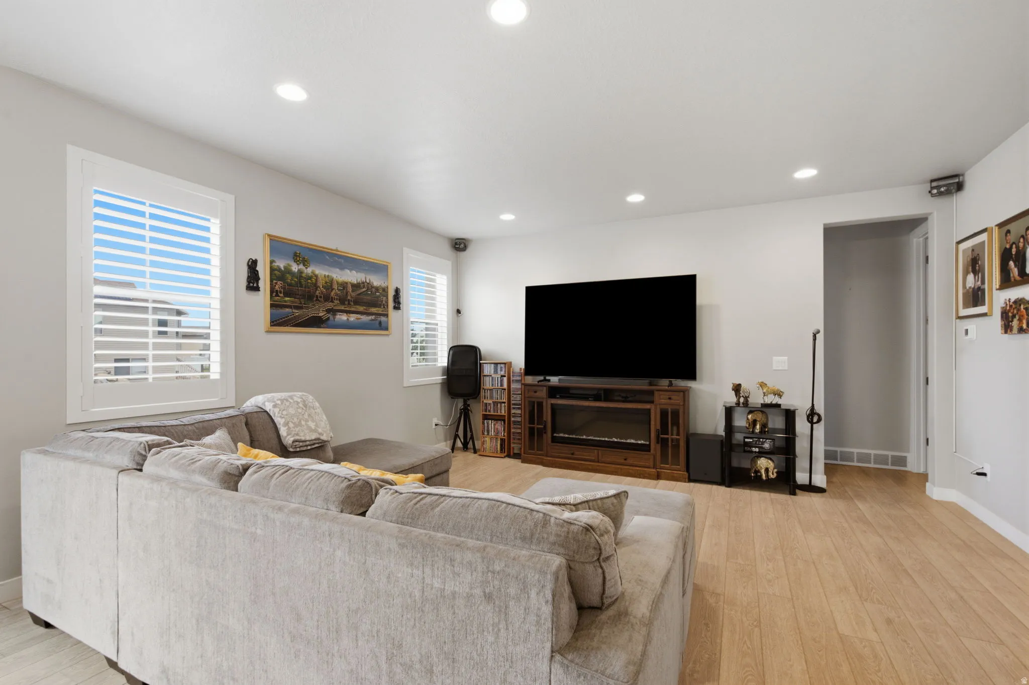 Living area featuring light wood-finish flooring and recessed lighting