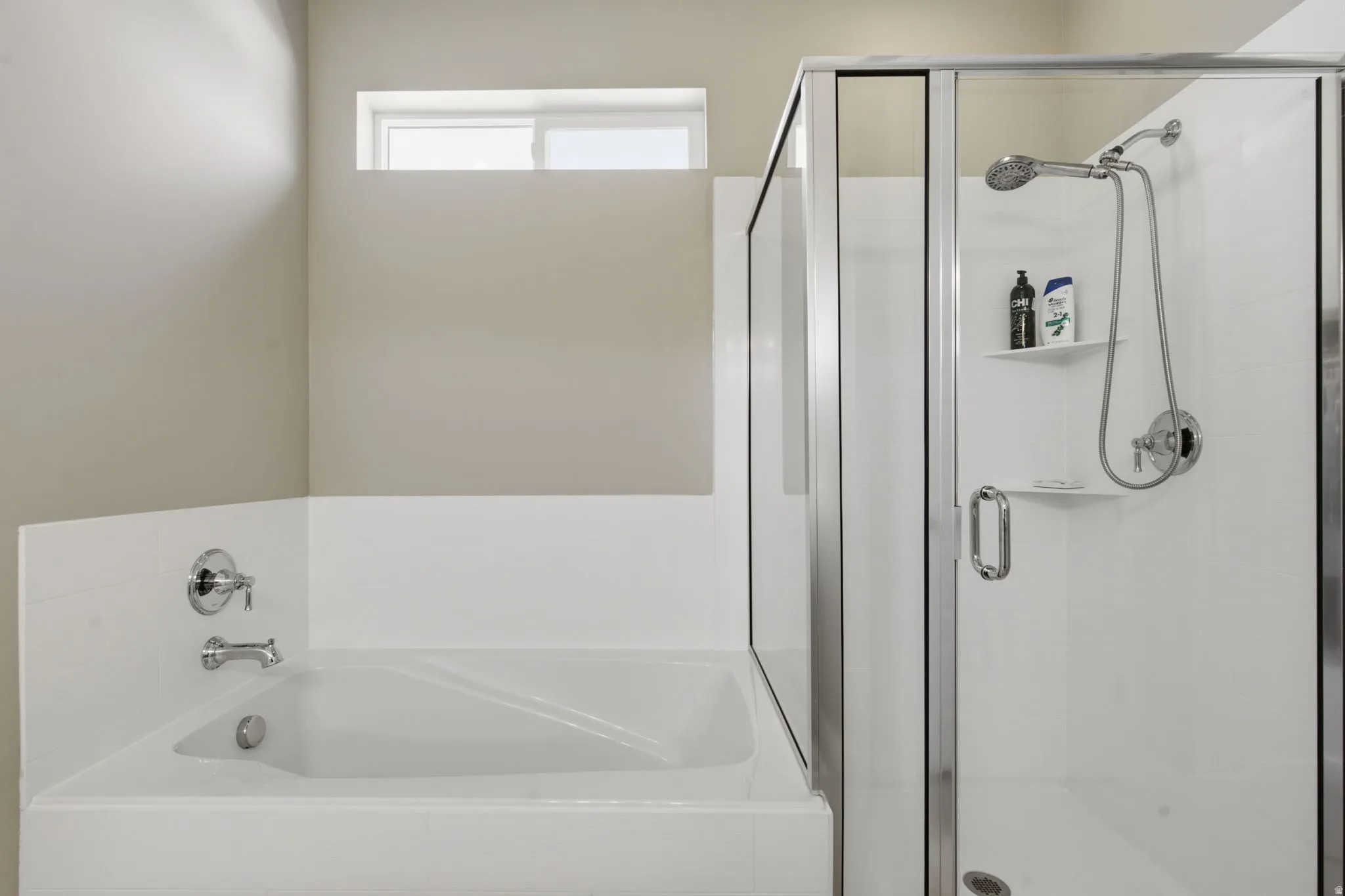Walk-in shower with clear glass enclosure and chrome fixtures