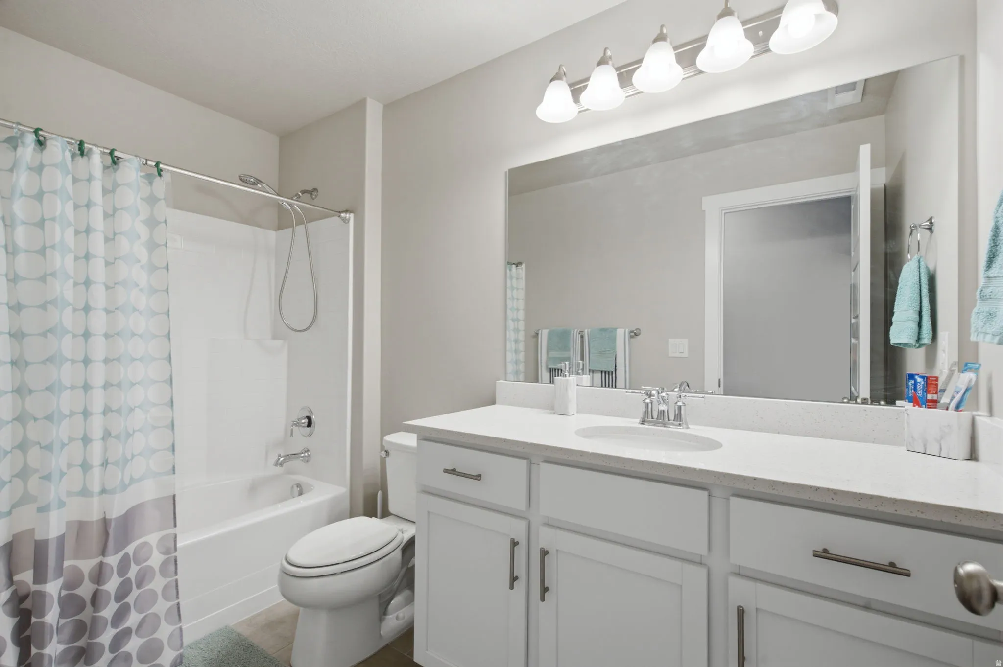 Bathroom featuring a spacious vanity with an integrated sink, ample counter space, and white cabinetry with brushed nickel hardware