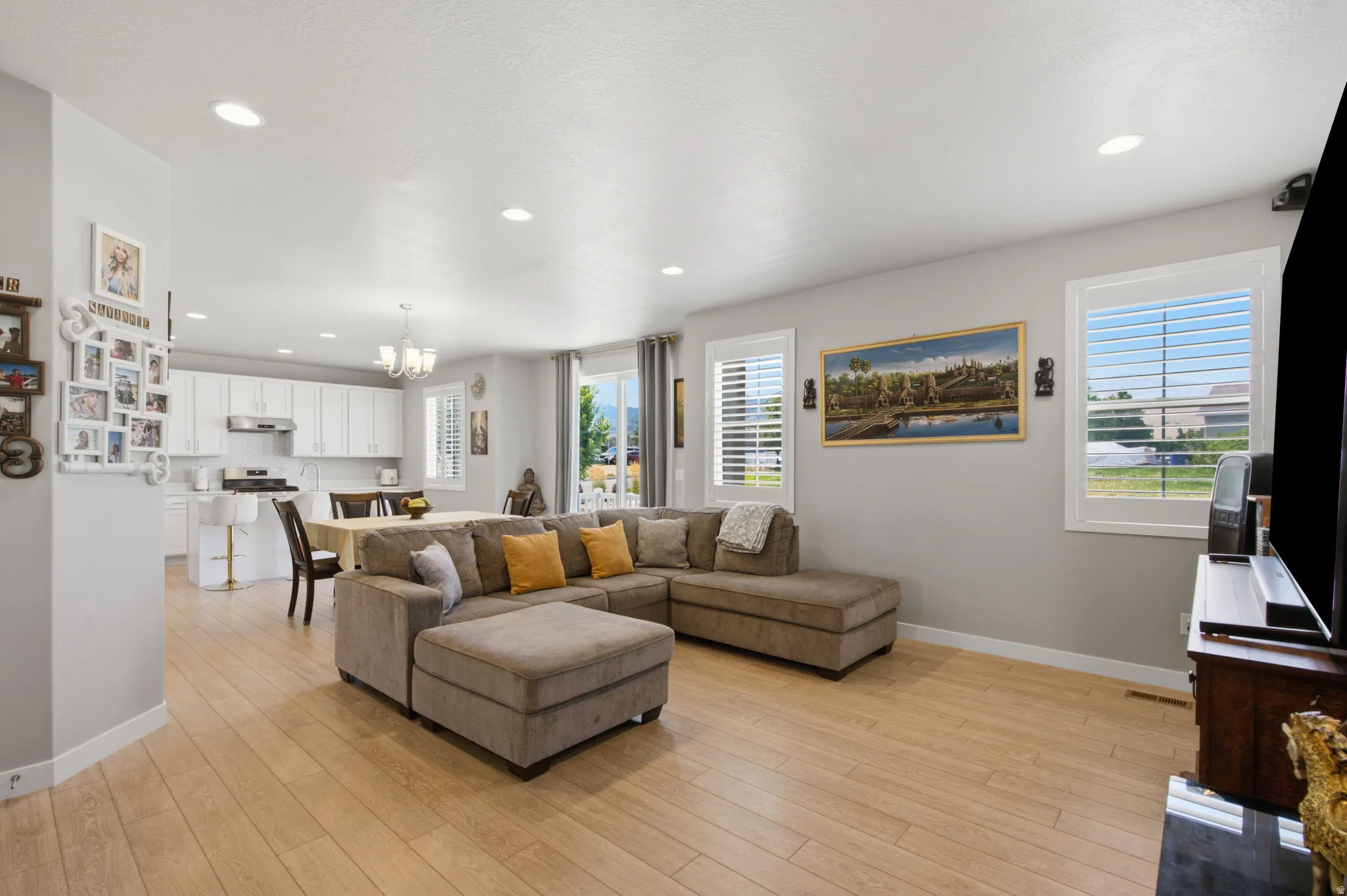 Open-concept living area with wood-finish flooring, recessed lighting, and light gray wall tones