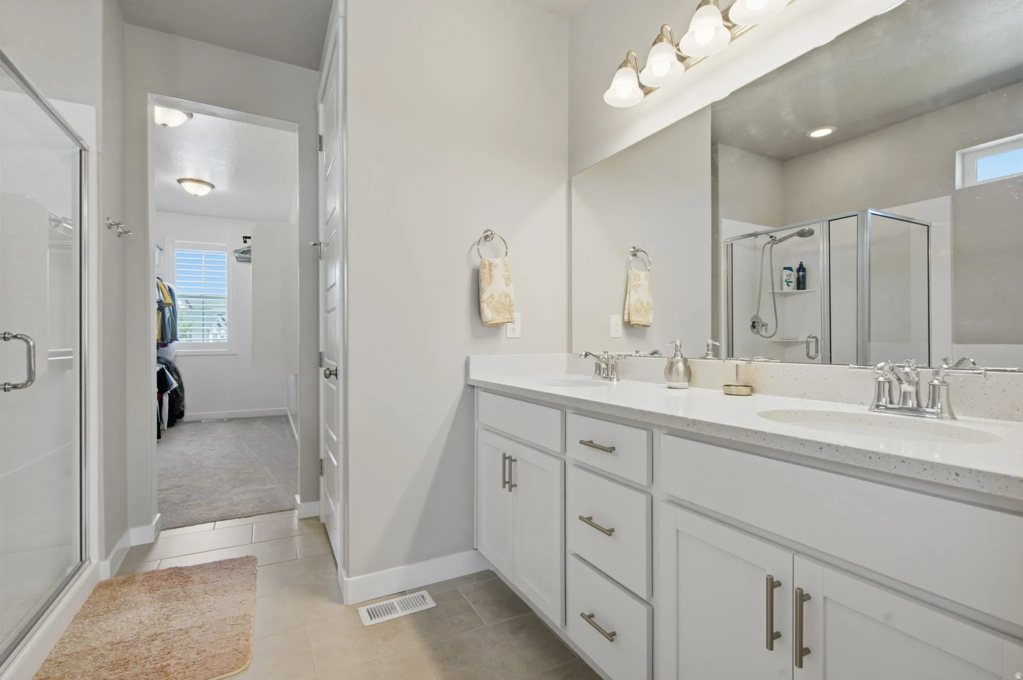 Dual vanity with integrated sinks, light-toned countertops, and brushed nickel fixtures