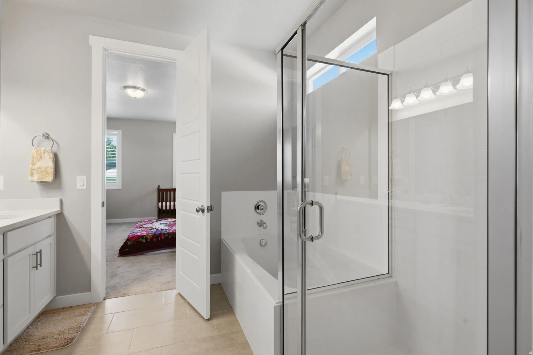 Glass-enclosed shower with white subway tile surround and integrated bathtub