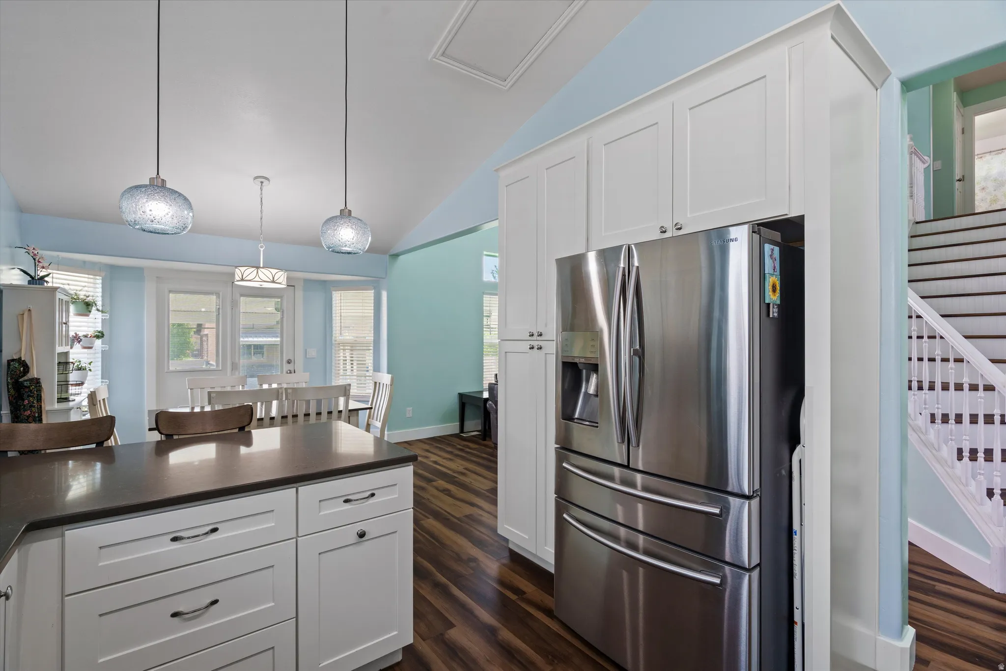 Kitchen island with a dark countertop and white cabinetry, complemented by two pendant lights
