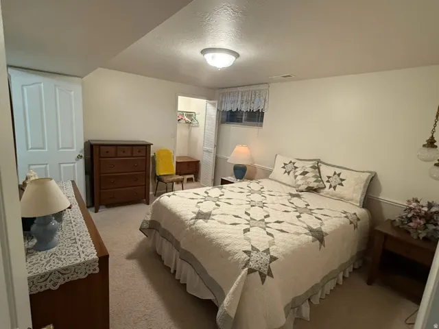 Carpeted room featuring a white paneled door, baseboard molding, a flush-mount ceiling light fixture, and a window with a valance