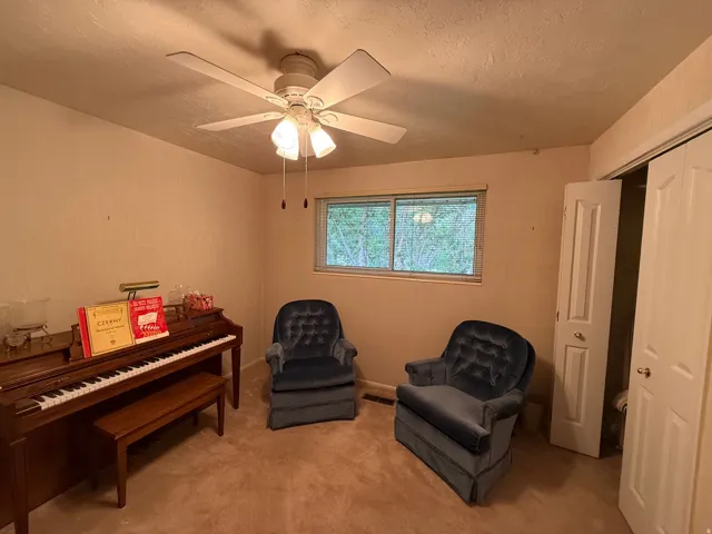 Interior room featuring a ceiling fan with integrated lighting, a window, and bifold closet doors