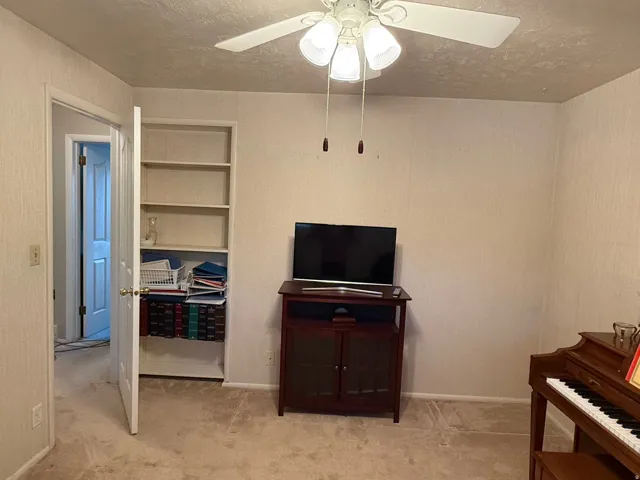 Room with light neutral wall covering and carpet flooring