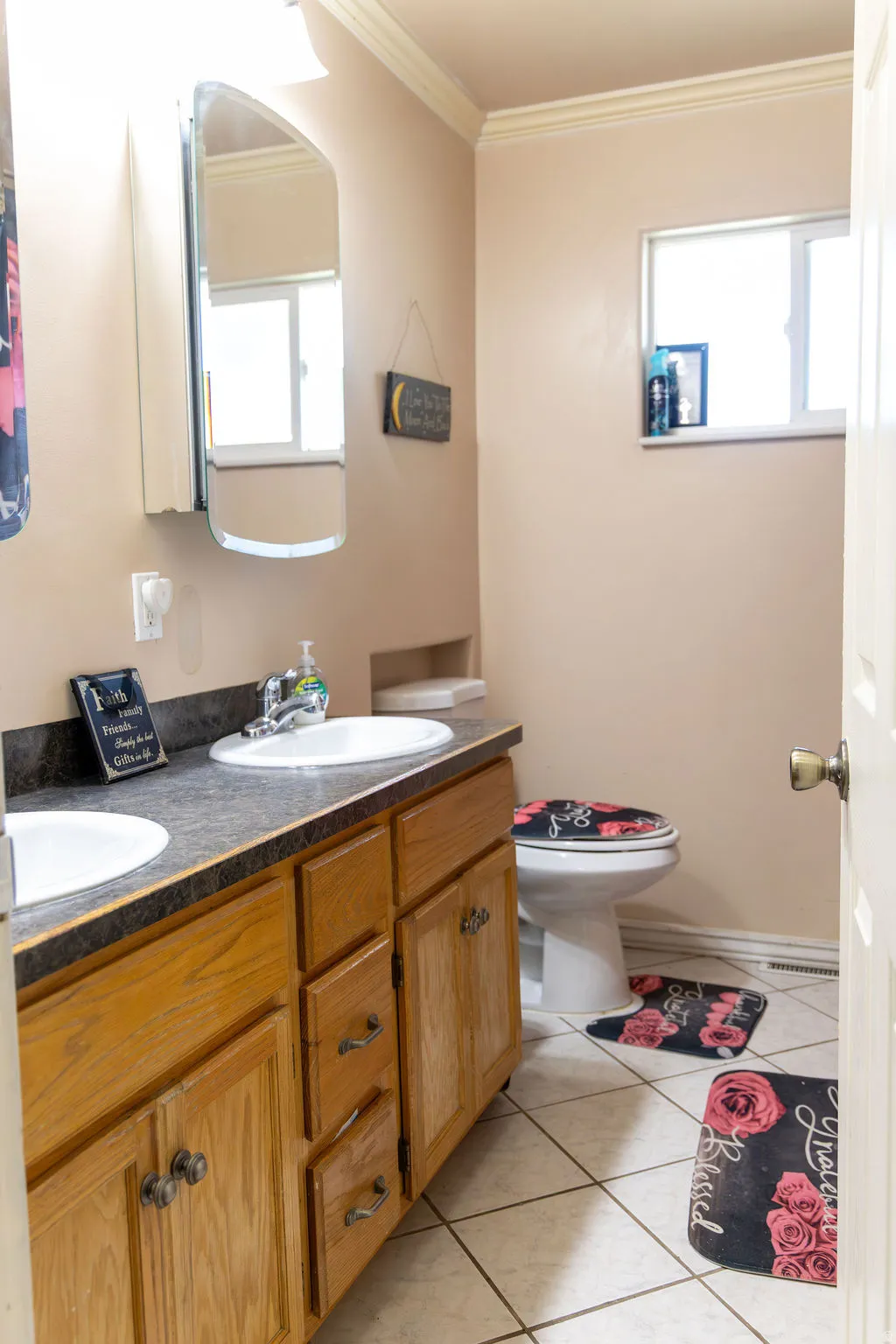 Dual basin vanity with wood cabinetry and dark countertops