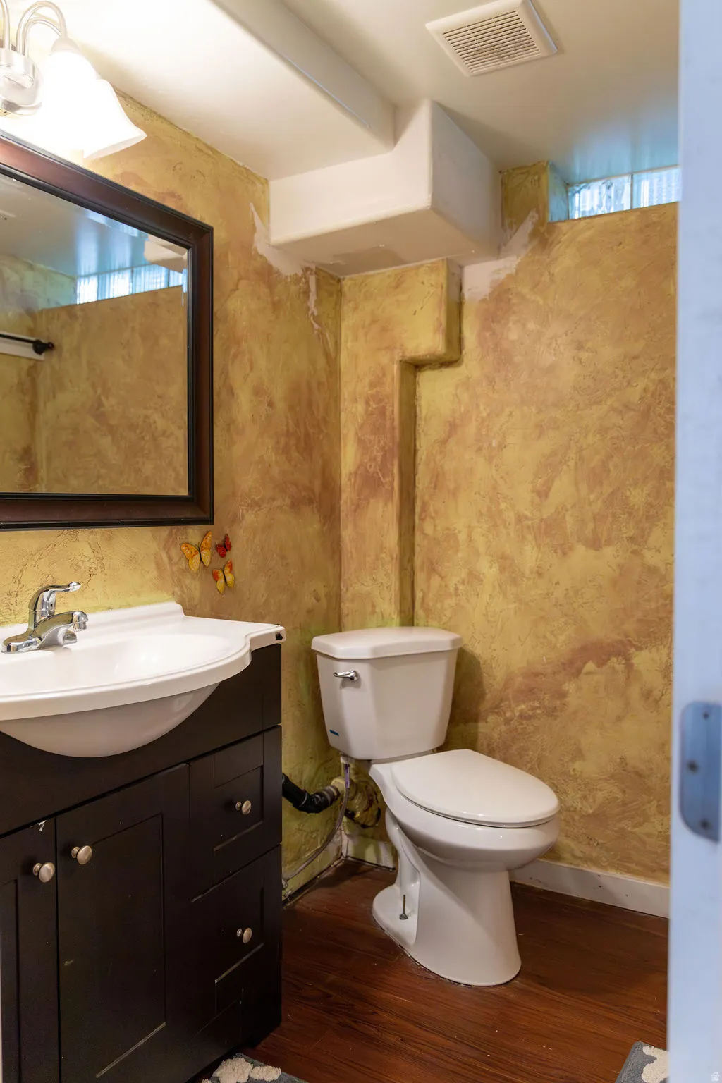 Bathroom featuring a contemporary vanity with an integrated sink, dark wood-finish cabinetry, and wood-finish flooring