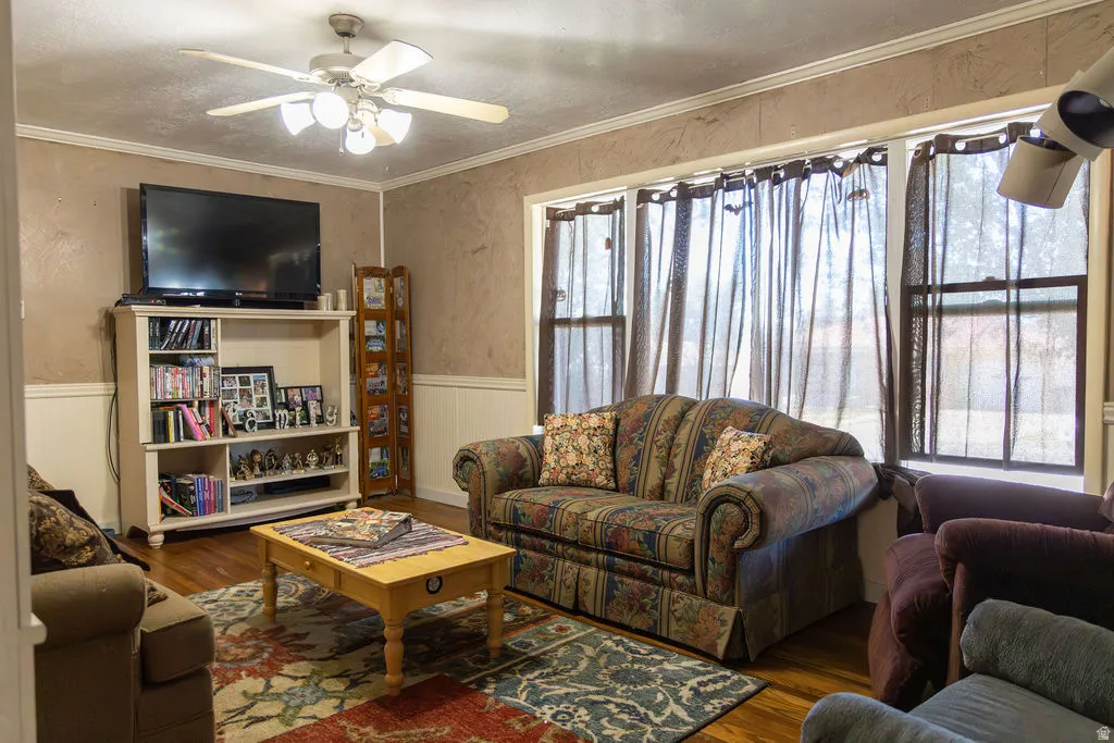 Living area featuring wood-finish flooring, wainscoting, and large windows