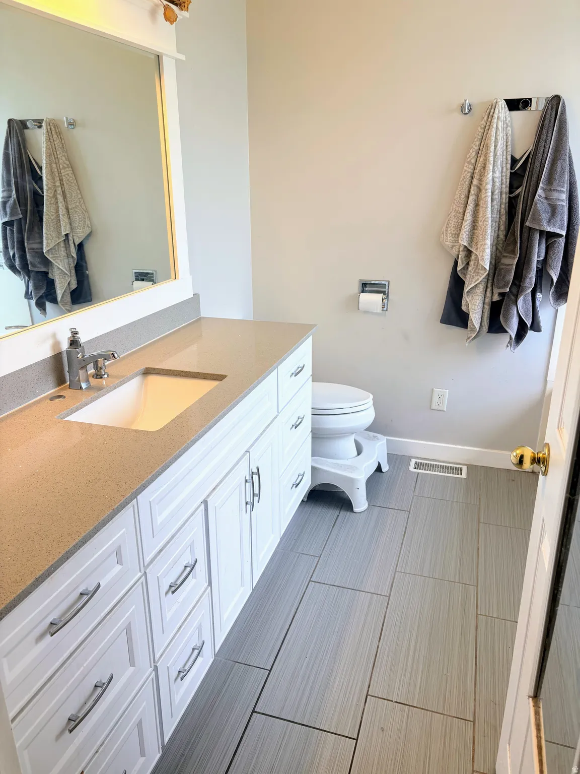 Master bathroom featuring a single vanity with white cabinetry, a light-toned countertop, and an undermount sink