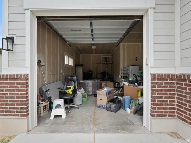 Attached two-car garage featuring a concrete floor and exposed framing