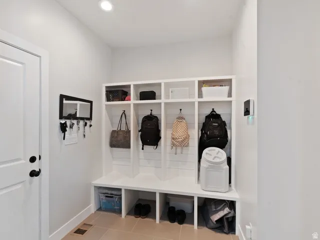 Built-in mudroom storage with individual cubbies, hooks, and bench seating