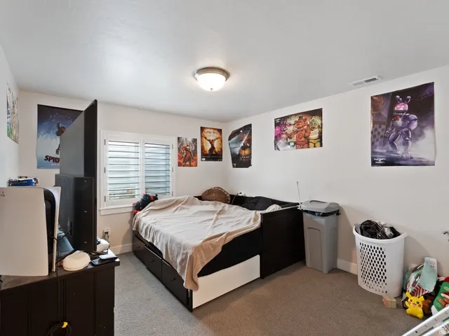 Carpeted room featuring a window with white plantation shutters, a flush-mount ceiling light fixture, and white baseboards