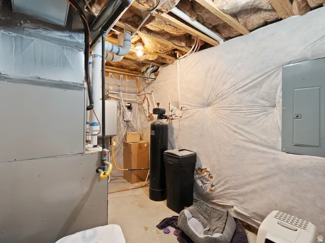 Utility space featuring exposed ceiling joists, insulation, and a water heater