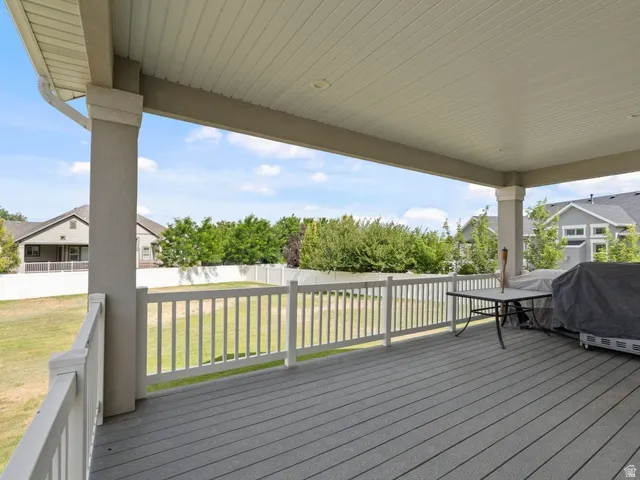 Expansive covered deck featuring composite decking, painted railing, and recessed lighting