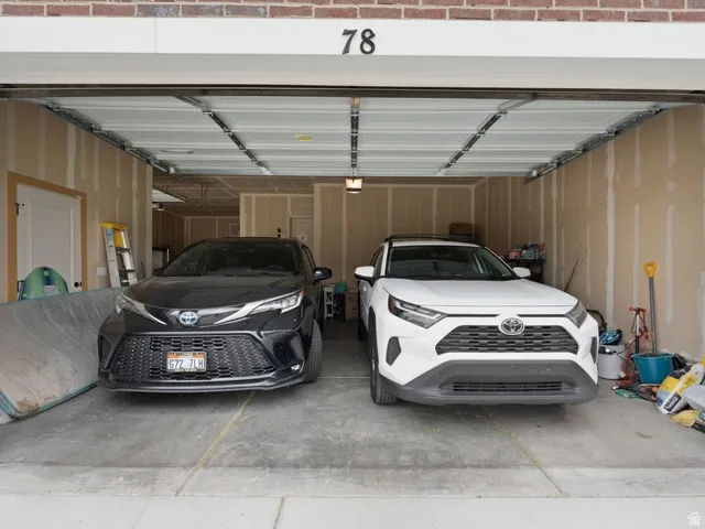 Two-car garage featuring exposed stud walls, concrete flooring, and an overhead garage door