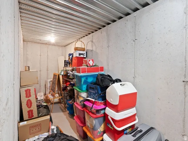 Unfinished basement area featuring exposed concrete walls and an open metal joist ceiling
