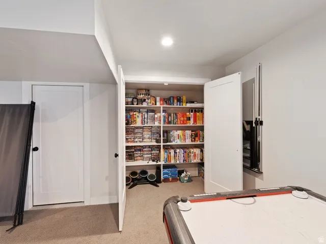 Recessed ceiling lighting illuminates a built-in shelving unit with adjustable shelves, providing extensive storage options