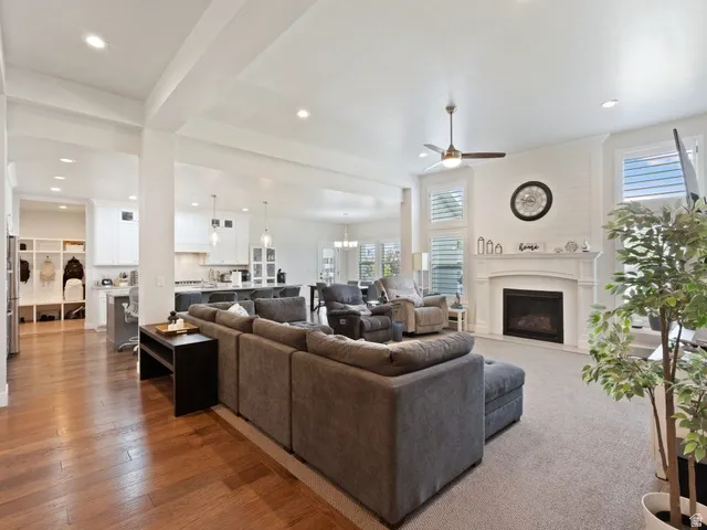 Living area featuring a fireplace with a mantel, shiplap accent wall, and recessed lighting