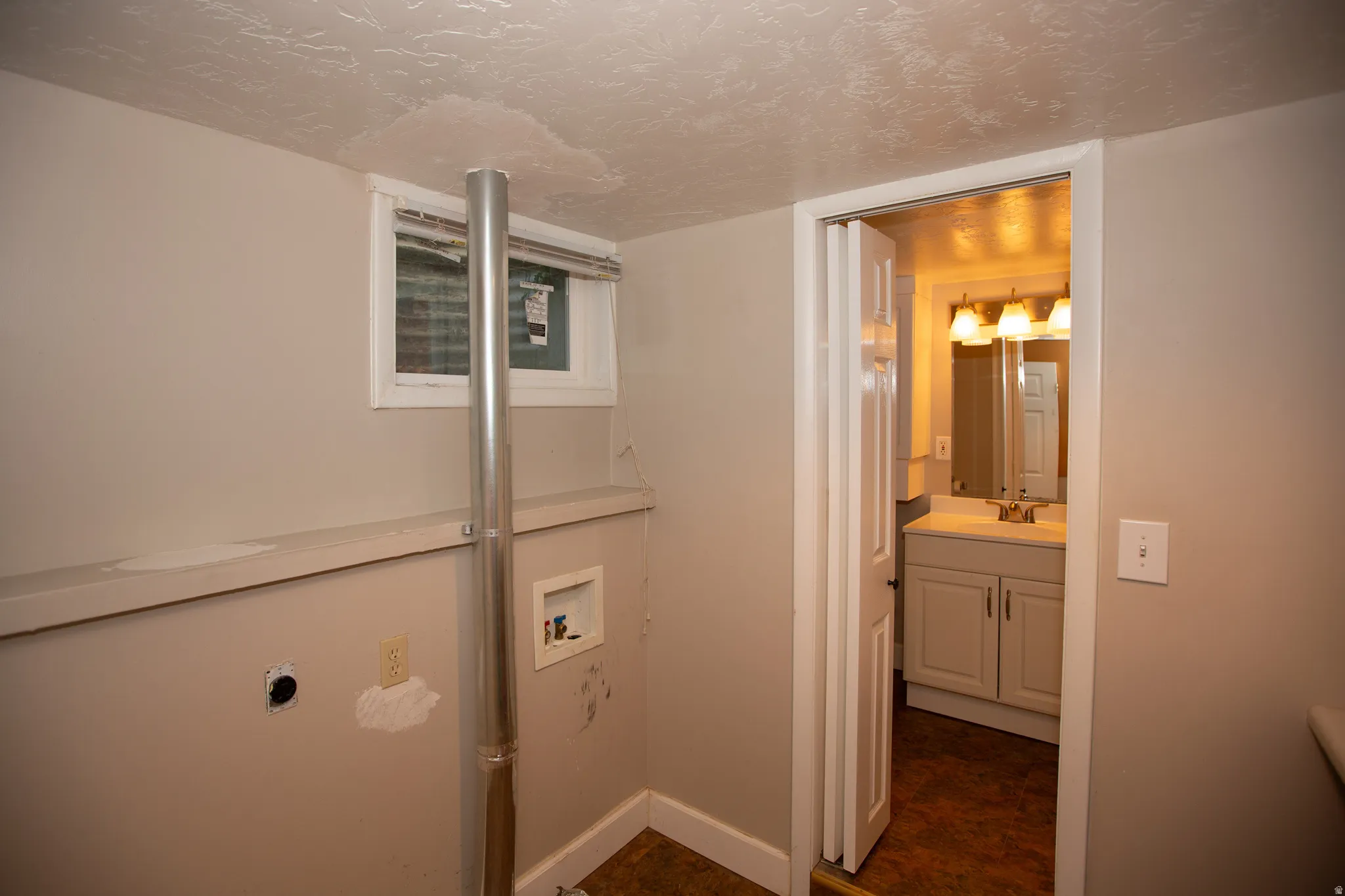 Utility area with light neutral wall paint, a small window with blinds, and durable flooring