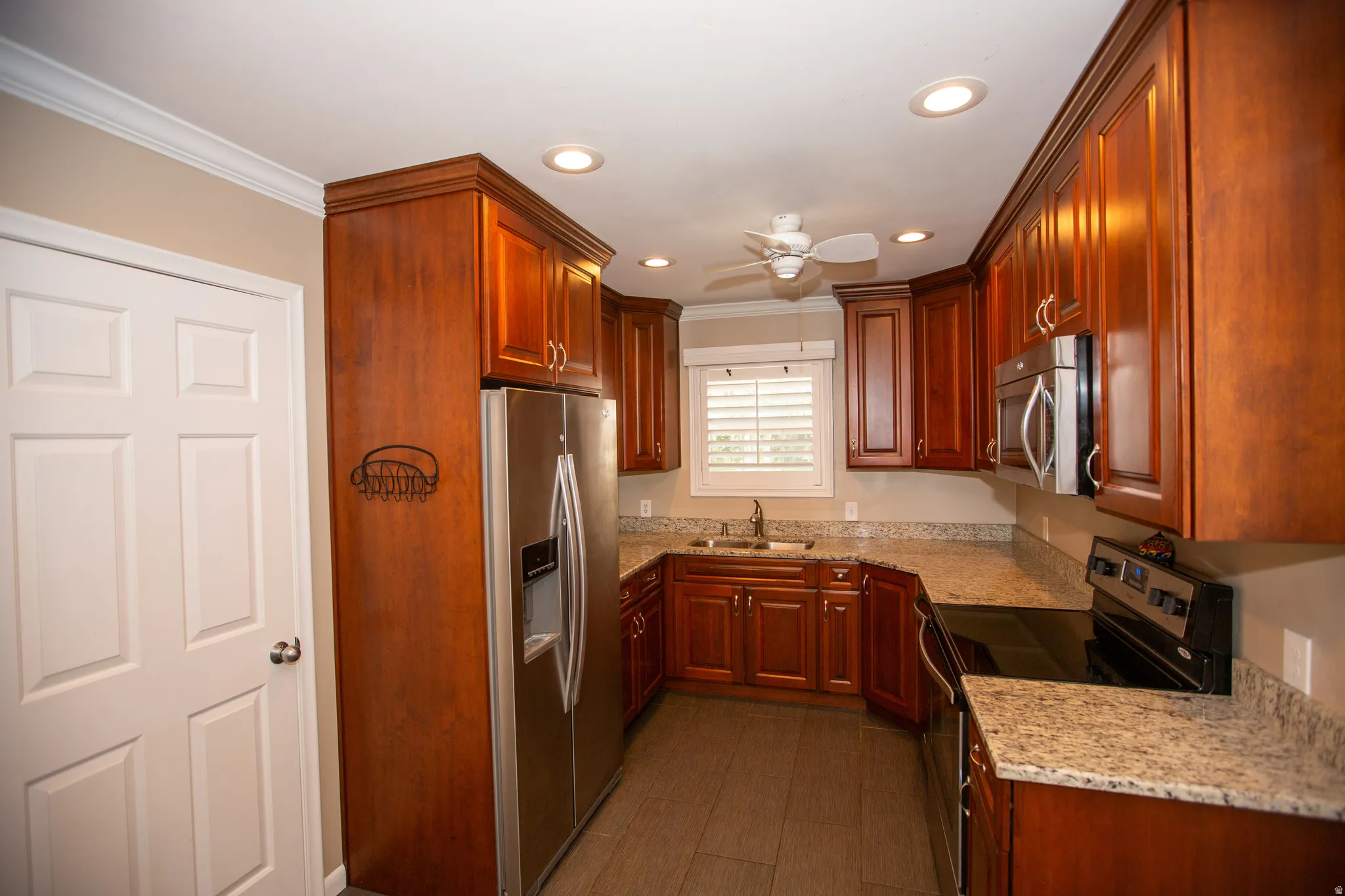 Kitchen with wood-finish cabinetry, granite countertops, and stainless steel appliances