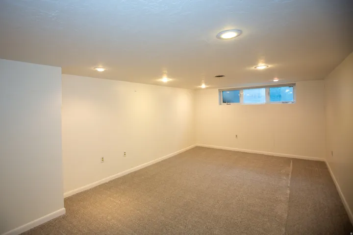 Carpeted room featuring recessed lighting, white walls, and a multi-pane window