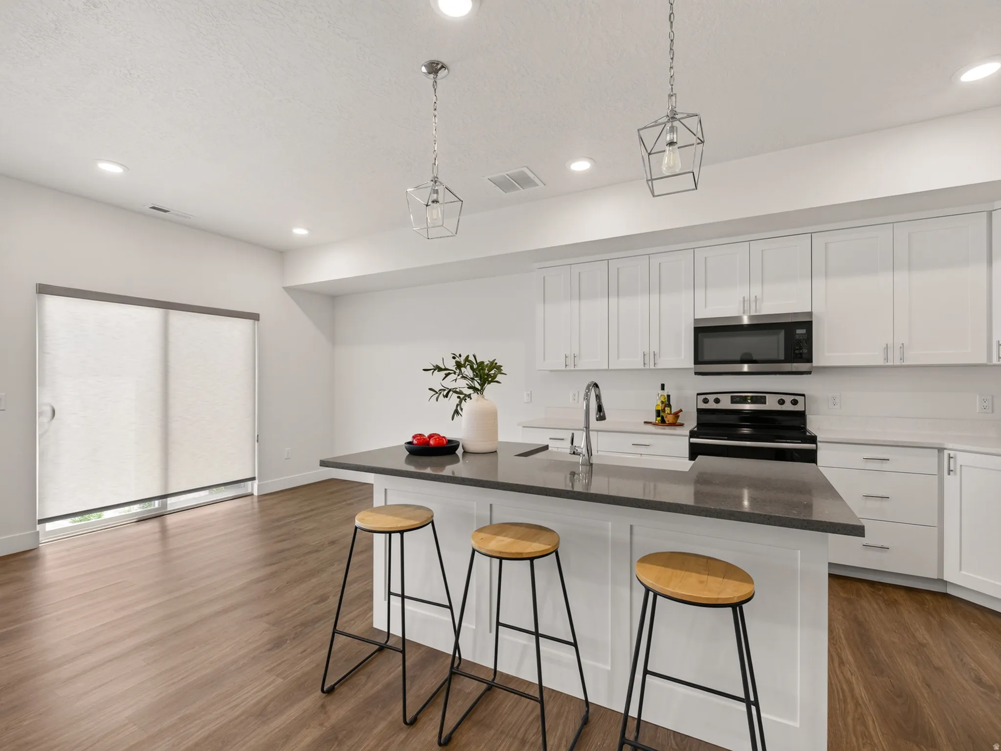 Upgraded kitchen with quartz countertops and white cabinetry.