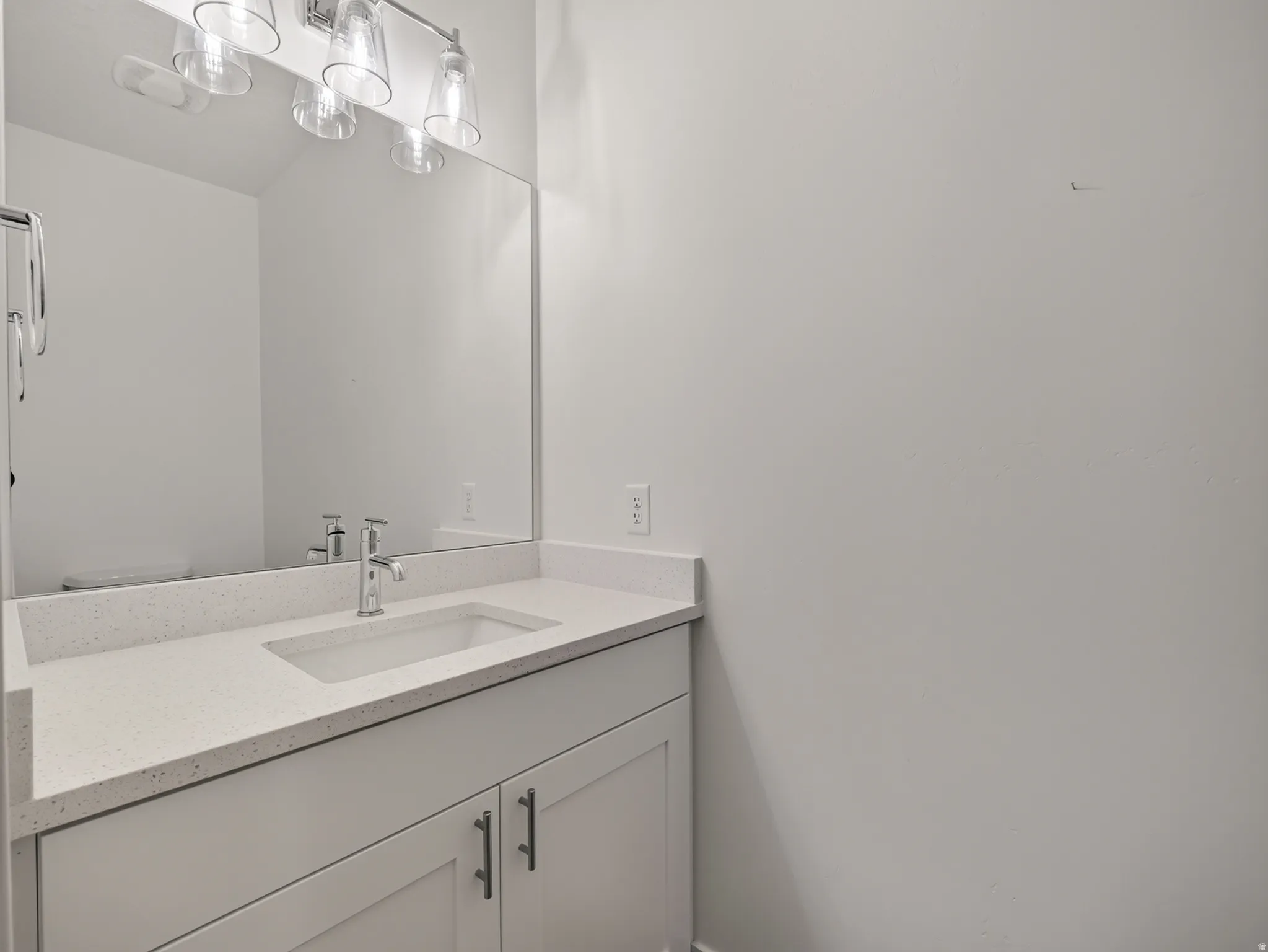 Single vanity featuring a white countertop with integrated sink and chrome faucet