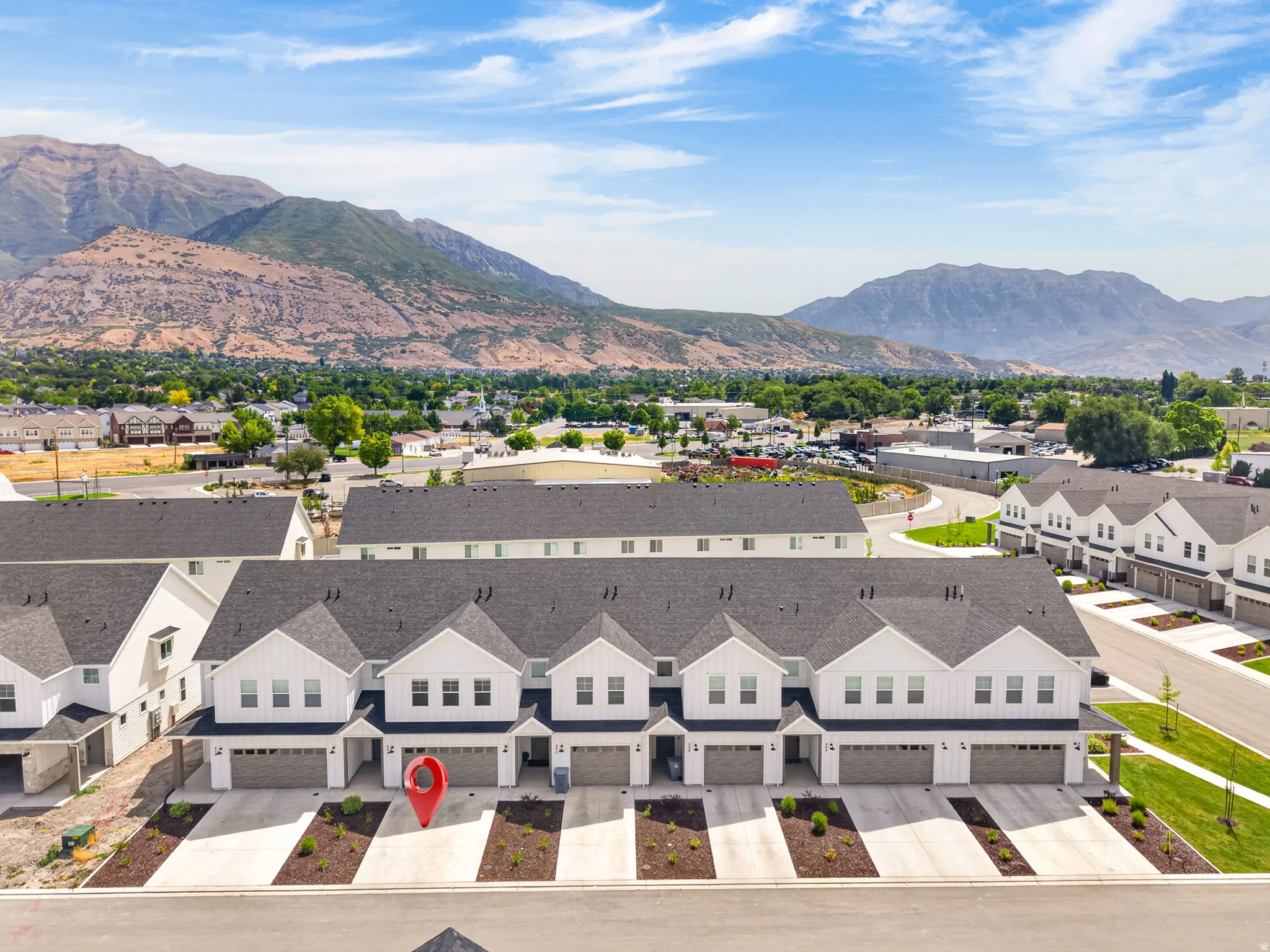 Modern townhome-style residences featuring white vertical siding and dark roofs