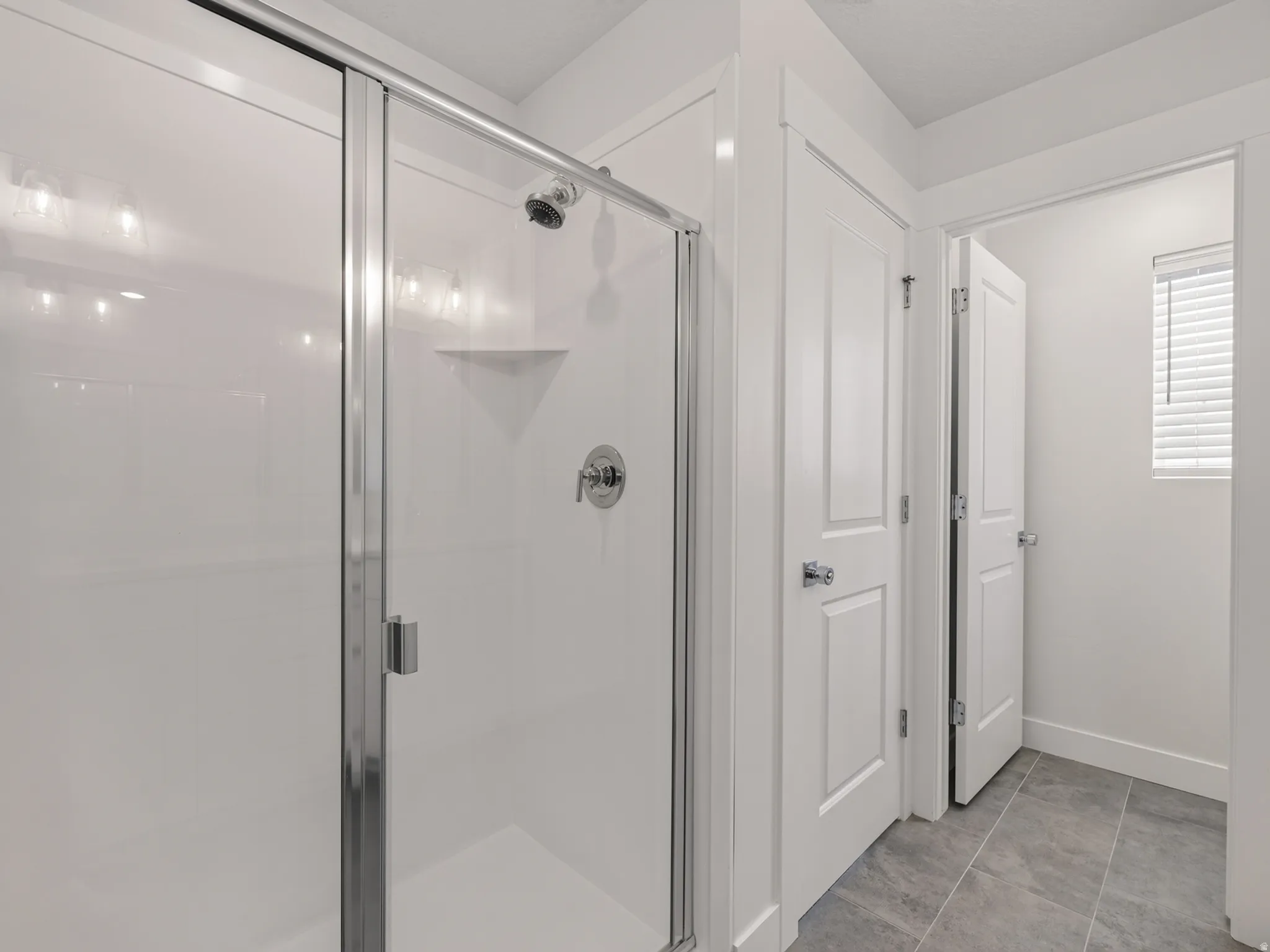 Shower enclosure with clear glass doors and chrome hardware