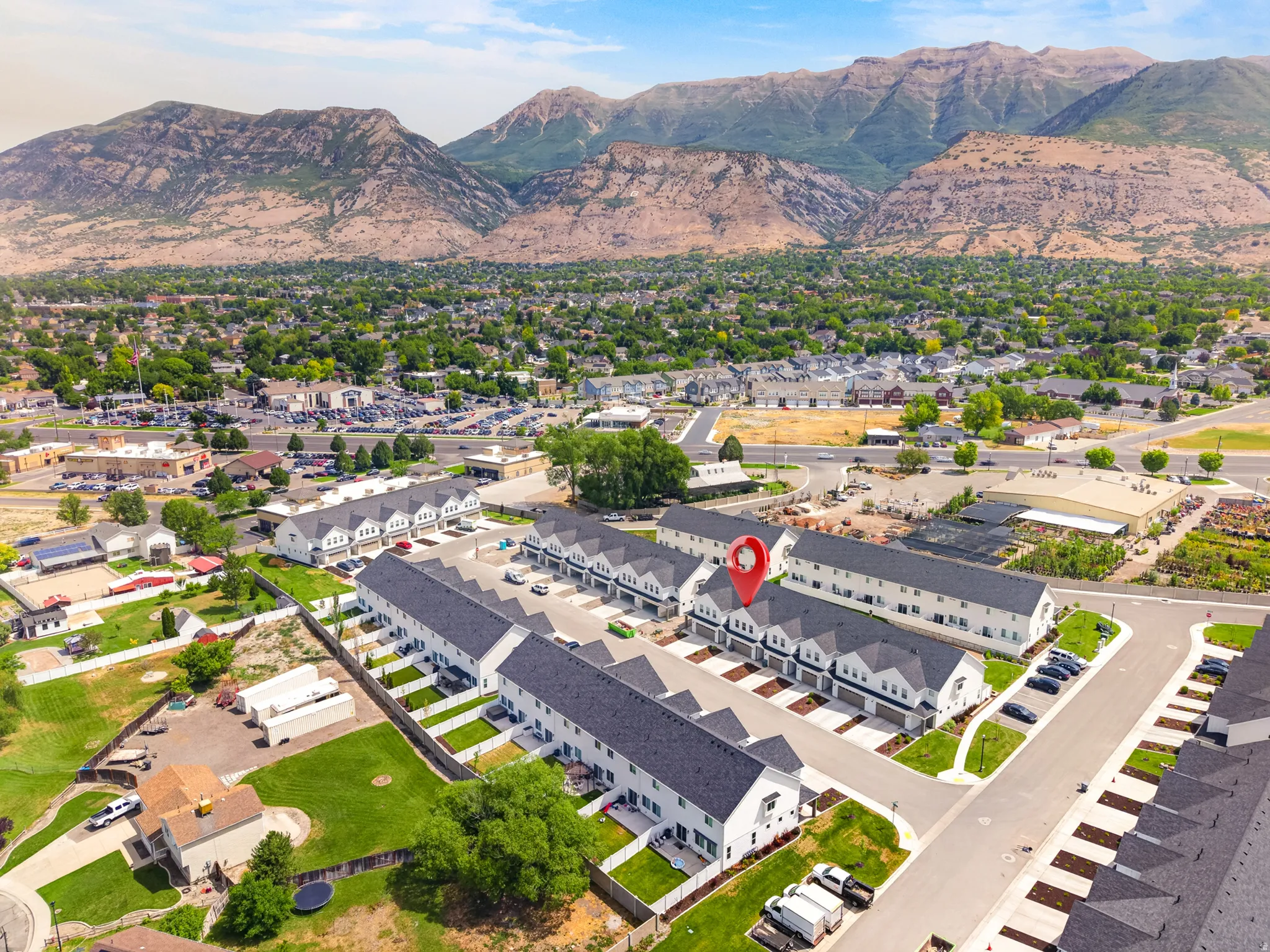 Rows of modern townhomes featuring white facades and dark roofs