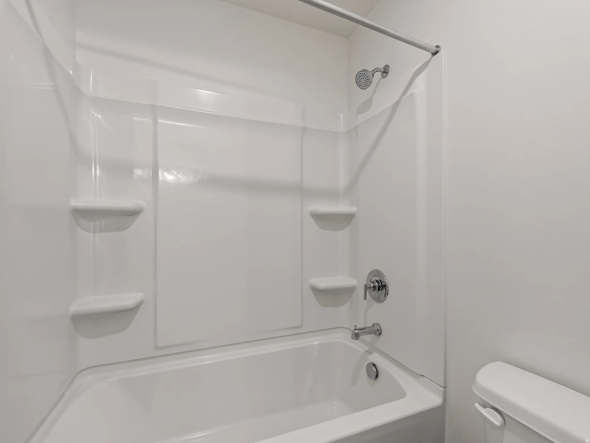 White shower/tub combination with integrated shelving