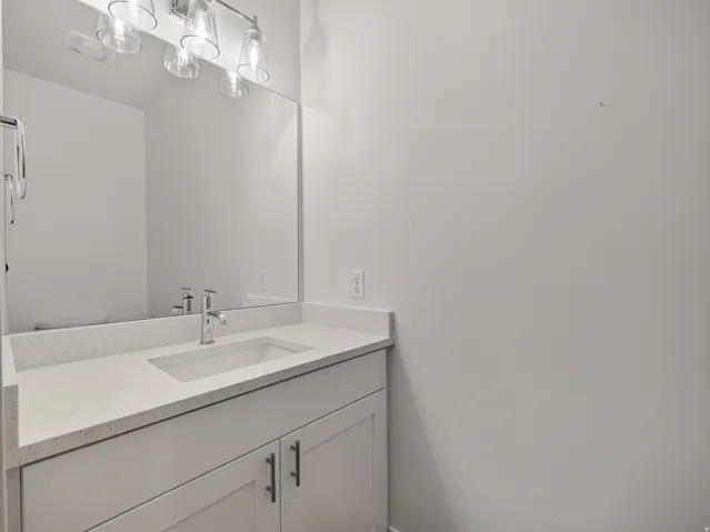 Single vanity featuring a white countertop with integrated sink and chrome faucet