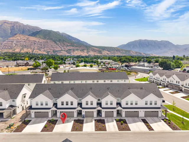 Modern townhome-style residences featuring white vertical siding and dark roofs