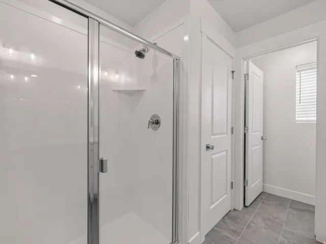 Shower enclosure with clear glass doors and chrome hardware