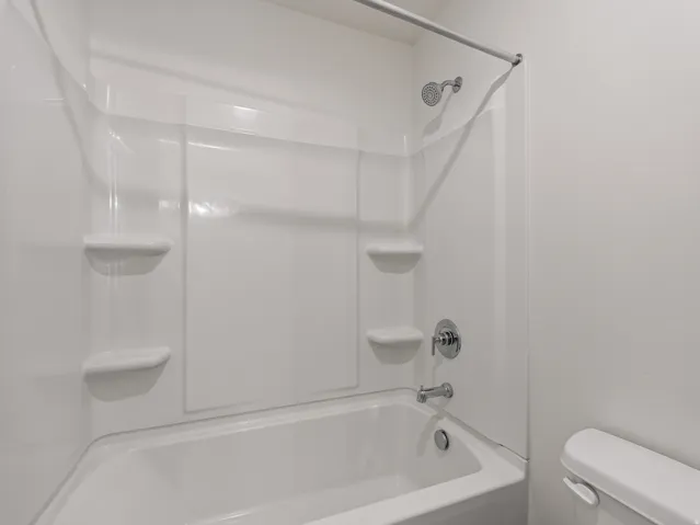 White shower/tub combination with integrated shelving